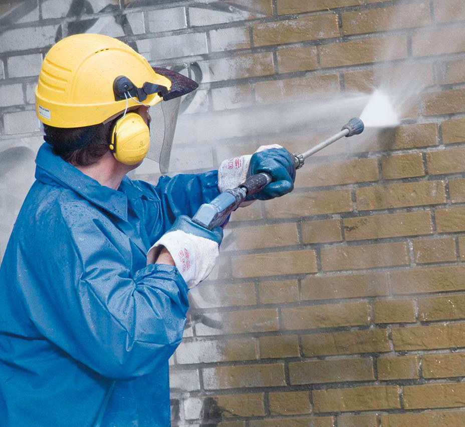 Worker Removing graffiti from the wall