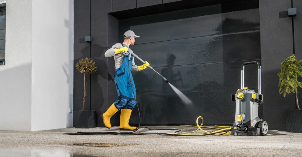 A property maintenance professional pressure washing a commercial property